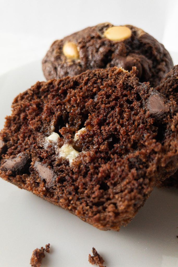 Ein Foto eines aufgeschnittenen Muffins mit weißen und dunklen Schokoladestücken. 